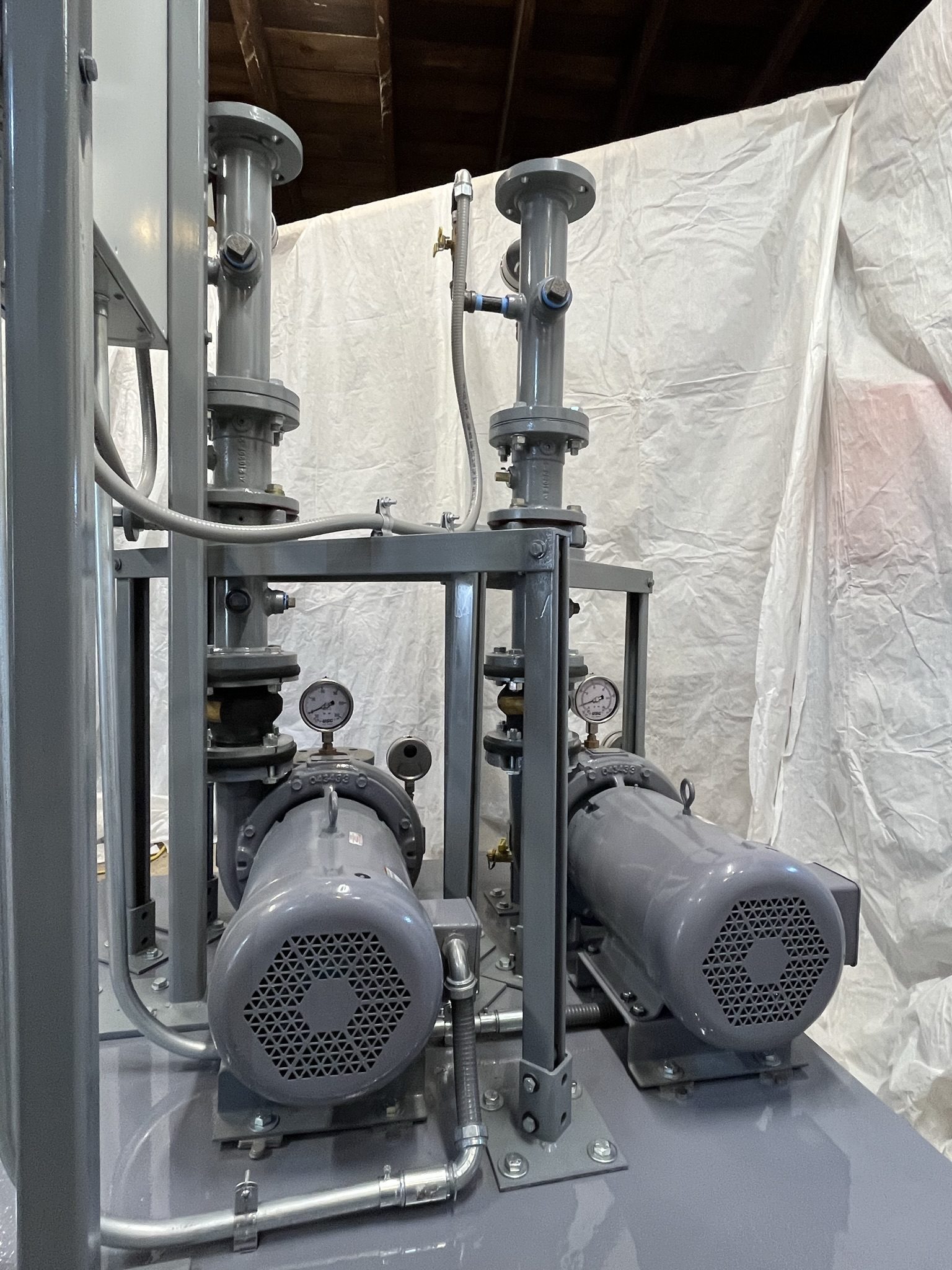 Close-up of duplex pump motors and pressure gauges